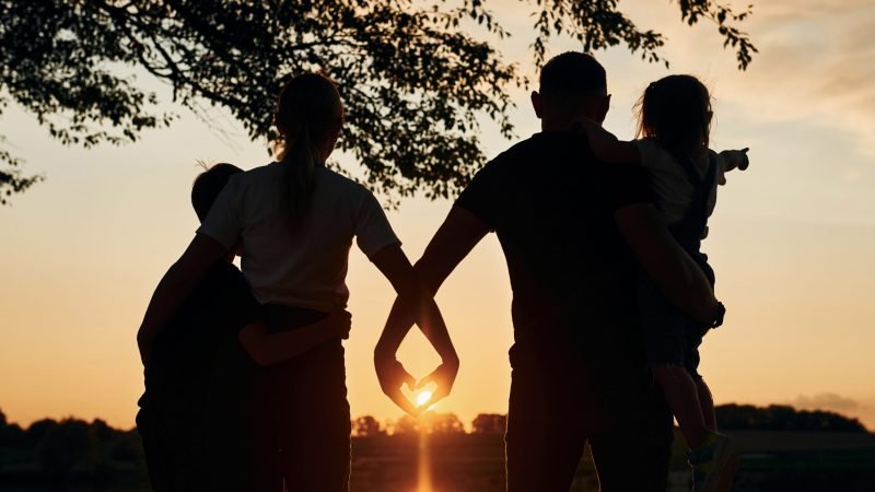 Looking at sunset. Family of mother, father and kids is on the camping.